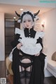 A woman dressed in a black and white maid outfit.