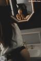 A woman is looking at herself in the mirror.