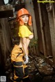 A woman in a yellow shirt and orange helmet posing for a picture.