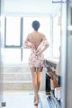 A woman standing in front of a mirror in a bathroom.